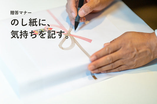 筆ペンでのし紙に文字を書く手元